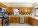 Traditional kitchen featuring wood cabinets, tiled backsplash, and stainless steel appliances at 122 S Green St, Brownsburg, IN 46112