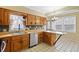 Bright kitchen showcasing wood cabinets, a stainless steel dishwasher and a breakfast bar area at 122 S Green St, Brownsburg, IN 46112