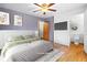 Staged main bedroom with hardwood floors, soft area rug, TV and ensuite bathroom at 122 S Green St, Brownsburg, IN 46112