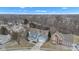 An aerial view shows this lovely home's location within a quiet, wooded neighborhood under a partly cloudy sky at 12404 Doe Ln, Indianapolis, IN 46236