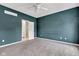 Inviting bedroom features teal walls, neutral carpet, ceiling fan and an en-suite bathroom at 12404 Doe Ln, Indianapolis, IN 46236
