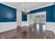 View of the dining room with wainscoting and blue walls, opening into a separate room at 12404 Doe Ln, Indianapolis, IN 46236