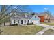 Charming two-story home with a manicured front yard, attached garage, and contrasting white and blue color scheme at 12404 Doe Ln, Indianapolis, IN 46236