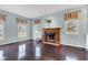 Cozy living room featuring hardwood floors, fireplace and soft neutral blue paint, and natural light at 12404 Doe Ln, Indianapolis, IN 46236