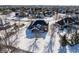 Winter aerial view of a brick house with a spacious snowy backyard, bordered by mature trees at 12978 Portsmouth Dr, Carmel, IN 46032