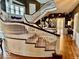 Grand foyer with a curved staircase, ornate banister, floral wallpaper, and views to other rooms at 1300 W University Ave, Muncie, IN 47303