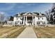 Grand home boasting a sprawling lawn, steps leading to covered entry, and symmetrical facade at 1300 W University Ave, Muncie, IN 47303