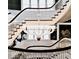 View of the staircase with dark wood railings, white spindles, and an ornate chandelier at 1300 W University Ave, Muncie, IN 47303
