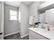 Bright bathroom featuring a gray vanity, mirror, and a window for natural light at 13115 N Departure W Blvd, Camby, IN 46113