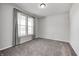 Bright carpeted bedroom with neutral walls, white trim, and a large window with light-filtering curtains at 13115 N Departure W Blvd, Camby, IN 46113