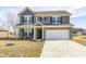 Charming two-story home features a brick and gray siding exterior, a welcoming front porch, and a two-car garage at 13115 N Departure W Blvd, Camby, IN 46113