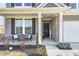 Inviting front porch with a seating area and a decorative front door with a wreath and a welcome sign at 13115 N Departure W Blvd, Camby, IN 46113