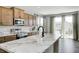 Well-lit kitchen featuring marble countertops, a stainless steel oven, and a view of the backyard at 13115 N Departure W Blvd, Camby, IN 46113