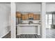 Modern kitchen with stainless steel appliances, a large island, and a view into a carpeted living space at 13115 N Departure W Blvd, Camby, IN 46113