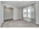 A carpeted room with light gray walls, three windows with light-filtering curtains, and white trim at 13115 N Departure W Blvd, Camby, IN 46113