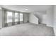 Spacious carpeted living room with large windows and gray walls; stairs and a white door are visible on the side at 13115 N Departure W Blvd, Camby, IN 46113