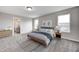 Staged primary bedroom boasts soft, neutral colors and ample natural light from multiple windows at 13115 N Departure W Blvd, Camby, IN 46113