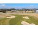 Aerial view of the community golf course with sand traps, lush green, and neighborhood homes in the distance at 16392 Grand Cypress Dr, Noblesville, IN 46060