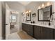 This bathroom features double sinks, framed mirrors, sleek fixtures, and a connecting bedroom at 16392 Grand Cypress Dr, Noblesville, IN 46060