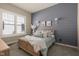 This bedroom features a blue accent wall with a window, wall sconces, and neutral carpeting at 16392 Grand Cypress Dr, Noblesville, IN 46060