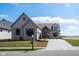 Charming home with gray brick, a manicured lawn, and a paved driveway leading to an attached garage at 16392 Grand Cypress Dr, Noblesville, IN 46060