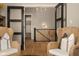 Bright foyer area with hardwood floors, two wicker chairs, an open door, and a glimpse of the staircase at 16392 Grand Cypress Dr, Noblesville, IN 46060