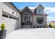 Exterior view of the home, featuring a gray brick facade, a two-car garage, and a welcoming front entrance at 16392 Grand Cypress Dr, Noblesville, IN 46060