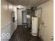 Basement utility area with water heater, pipes, and HVAC equipment along the wall; window for natural light at 1925 N Leland Ave, Indianapolis, IN 46218