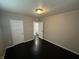 Bedroom with neutral walls and a view to the bathroom; dark hardwood flooring; standard ceiling light fixture at 1925 N Leland Ave, Indianapolis, IN 46218