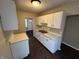 Efficient kitchen featuring white cabinets, countertops, and dark wood flooring at 1925 N Leland Ave, Indianapolis, IN 46218