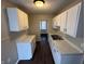 Efficient kitchen featuring white cabinets, countertops, and modern appliances at 1925 N Leland Ave, Indianapolis, IN 46218