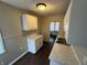 Efficient kitchen featuring white cabinets, countertops, and dark wood flooring at 1925 N Leland Ave, Indianapolis, IN 46218