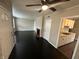 Inviting living room features black flooring, a ceiling fan, and a view into the kitchen at 1925 N Leland Ave, Indianapolis, IN 46218