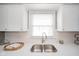 Bright kitchen featuring white cabinets, stainless steel sink, and subway tile backsplash at 208 Northshore Blvd, Anderson, IN 46011