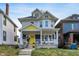 Charming two-story home with a welcoming front porch, swing, and colorful flower pots at 3145 N New Jersey St, Indianapolis, IN 46205