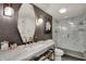 Modern bathroom featuring a marble countertop, a stylish mirror, and a glass-enclosed shower at 3517 Brumley Way, Carmel, IN 46033