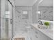 This bathroom features white marble tiling, double sinks, modern fixtures, and a glass shower enclosure at 44 Kessler Blvd W Dr, Indianapolis, IN 46208