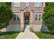 Building entrance featuring stone steps, potted plants, and a well-maintained lawn at 450 E Ohio St # Apt 118, Indianapolis, IN 46204