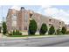 Brick apartment building featuring balconies, lush greenery, and well-maintained landscaping at 450 E Ohio St # Apt 118, Indianapolis, IN 46204