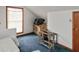 Unfinished attic space with blue carpeting, window, and interior door at 518 E College Ave, Brownsburg, IN 46112