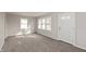 Bright living room with multiple windows and neutral carpet at 518 E College Ave, Brownsburg, IN 46112