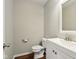 Bathroom featuring white vanity and sink, toilet, and dark wood floors at 5546 W Vistaview Trl, McCordsville, IN 46055