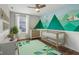 Nicely decorated bedroom with mountain mural, crib, and hardwood floors at 5546 W Vistaview Trl, McCordsville, IN 46055
