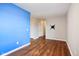 Bedroom with hardwood floors, blue accent wall, and hallway access at 5546 W Vistaview Trl, McCordsville, IN 46055