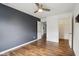 The bedroom features a dark gray accent wall, hardwood floors, ceiling fan and open closet space at 5546 W Vistaview Trl, McCordsville, IN 46055