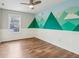 bedroom with mountain mural, white wainscoting, window, and hardwood floors at 5546 W Vistaview Trl, McCordsville, IN 46055