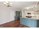 Open kitchen with eat in island, stainless steel refrigerator and appliances, and dark wood floors at 5546 W Vistaview Trl, McCordsville, IN 46055