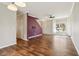 Open living room with hardwood floors, purple accent wall, staircase, and large windows at 5546 W Vistaview Trl, McCordsville, IN 46055