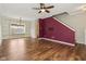 Spacious living area with hardwood floors, a purple accent wall, and a staircase to the upper level at 5546 W Vistaview Trl, McCordsville, IN 46055