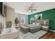 Main bedroom with green accent wall, ceiling fan, bed, and hardwood floors at 5546 W Vistaview Trl, McCordsville, IN 46055